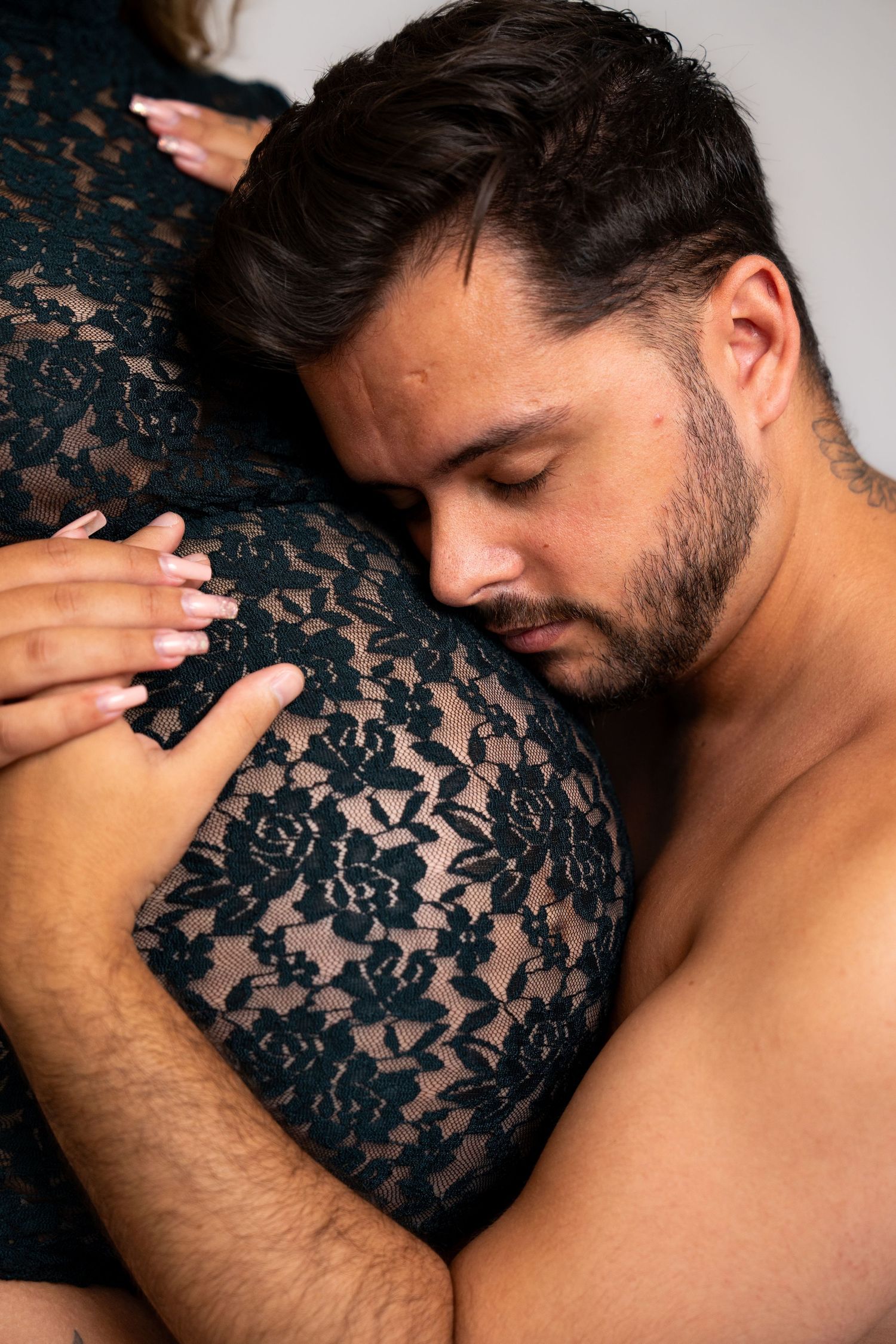 Intimate couple photoshoot featuring romantic poses in dark lace attire.