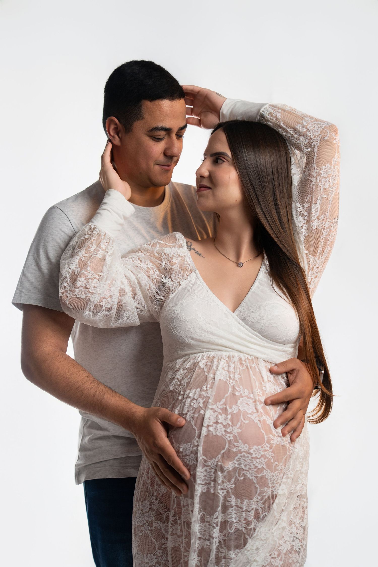 Romantic maternity photos featuring sheer white lace gown.