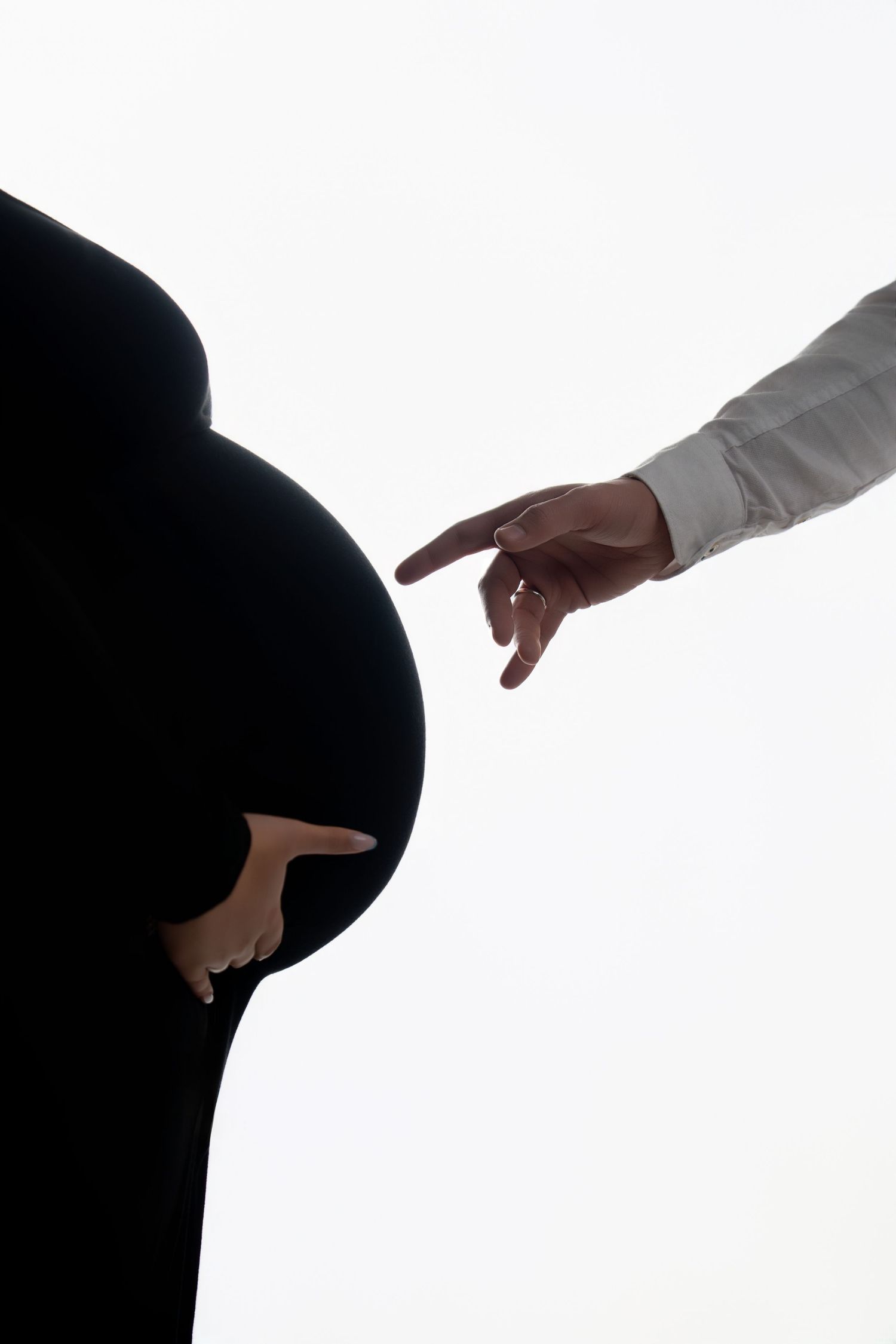 Silhouette pregnancy photos with reaching hand against white background.