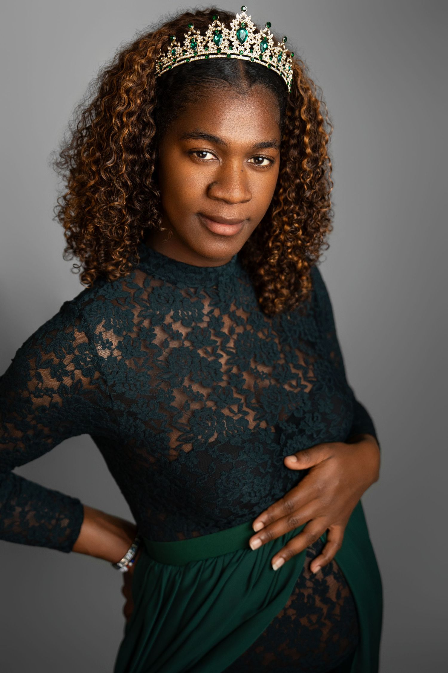 Elegant portrait session featuring black lace top, green dress and crystal crown.