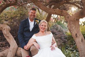 Romantic wedding photos captured under twisted tree branches in natural setting.
