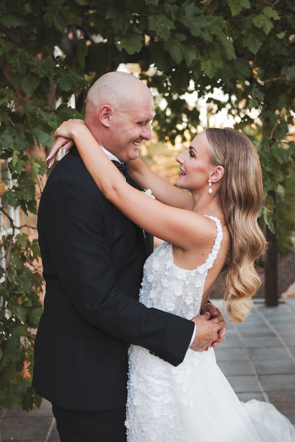 Couple shares joyful dance moment during outdoor wedding celebration.