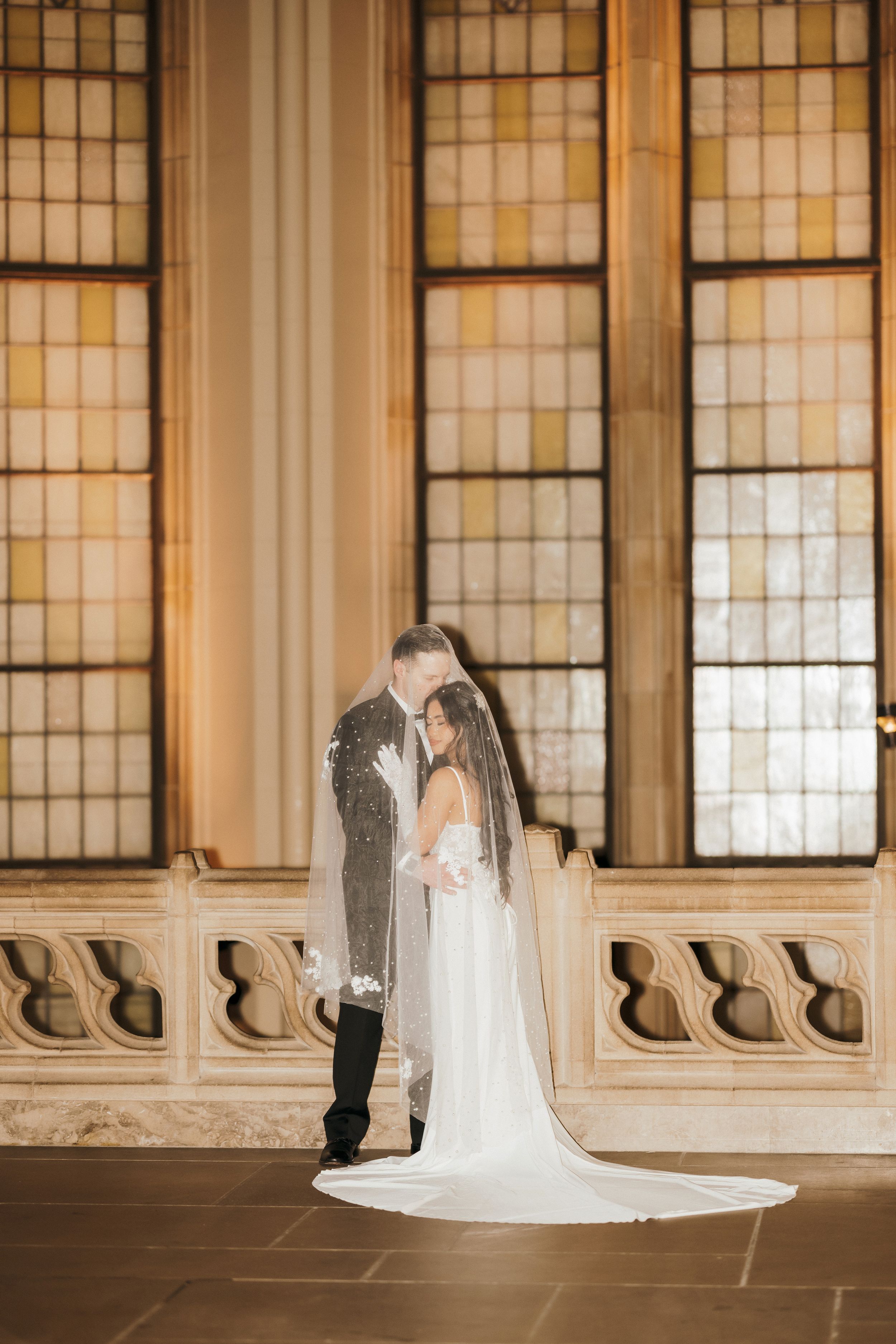 Wedding couple photographed in dramatic sequence along historic hallway with ornate windows.