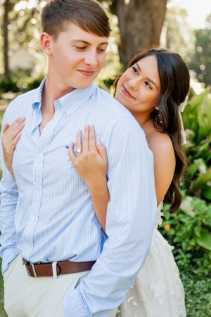 Romantic couple in blue and white outfits sharing tender moment outdoors.