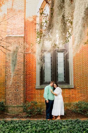A romantic photoshoot against a historic brick building with Spanish moss.