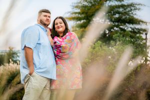 A couple shares a romantic moment together in a natural outdoor setting with trees in the background.