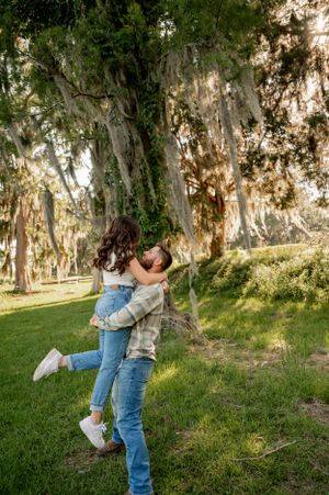 Couple dancing and spinning joyfully in a sunlit forest clearing.
