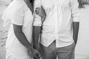 A tender moment captured in black and white on a sandy beach.