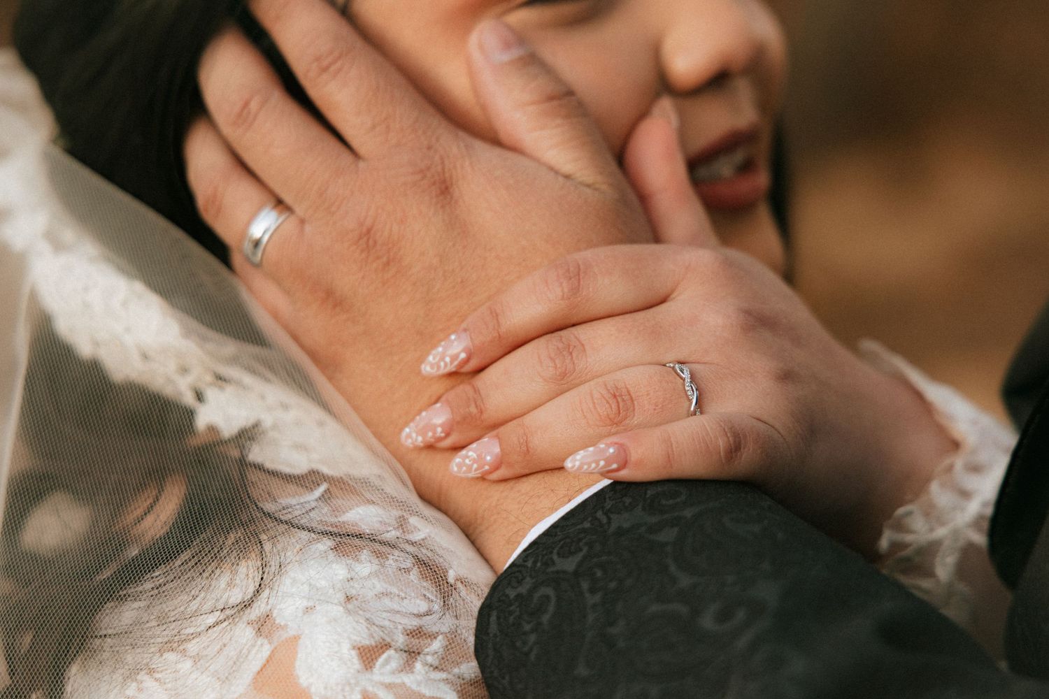 A couple shares a romantic kiss during their wedding ceremony with guests in the background.