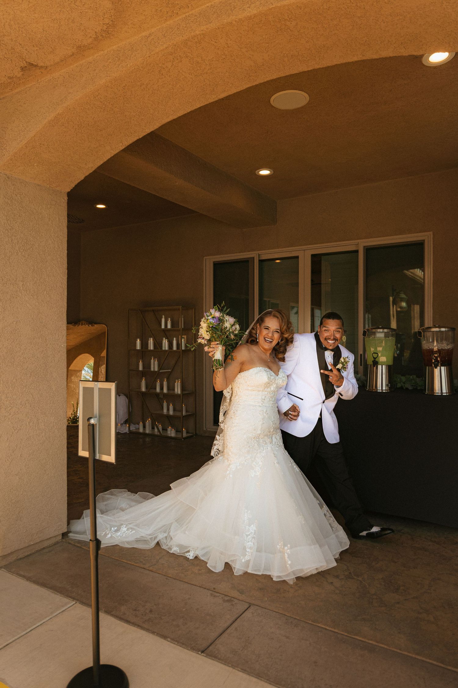 A reception venue with white arched ceilings, stone floors, and subdued lighting creating an elegant atmosphere.