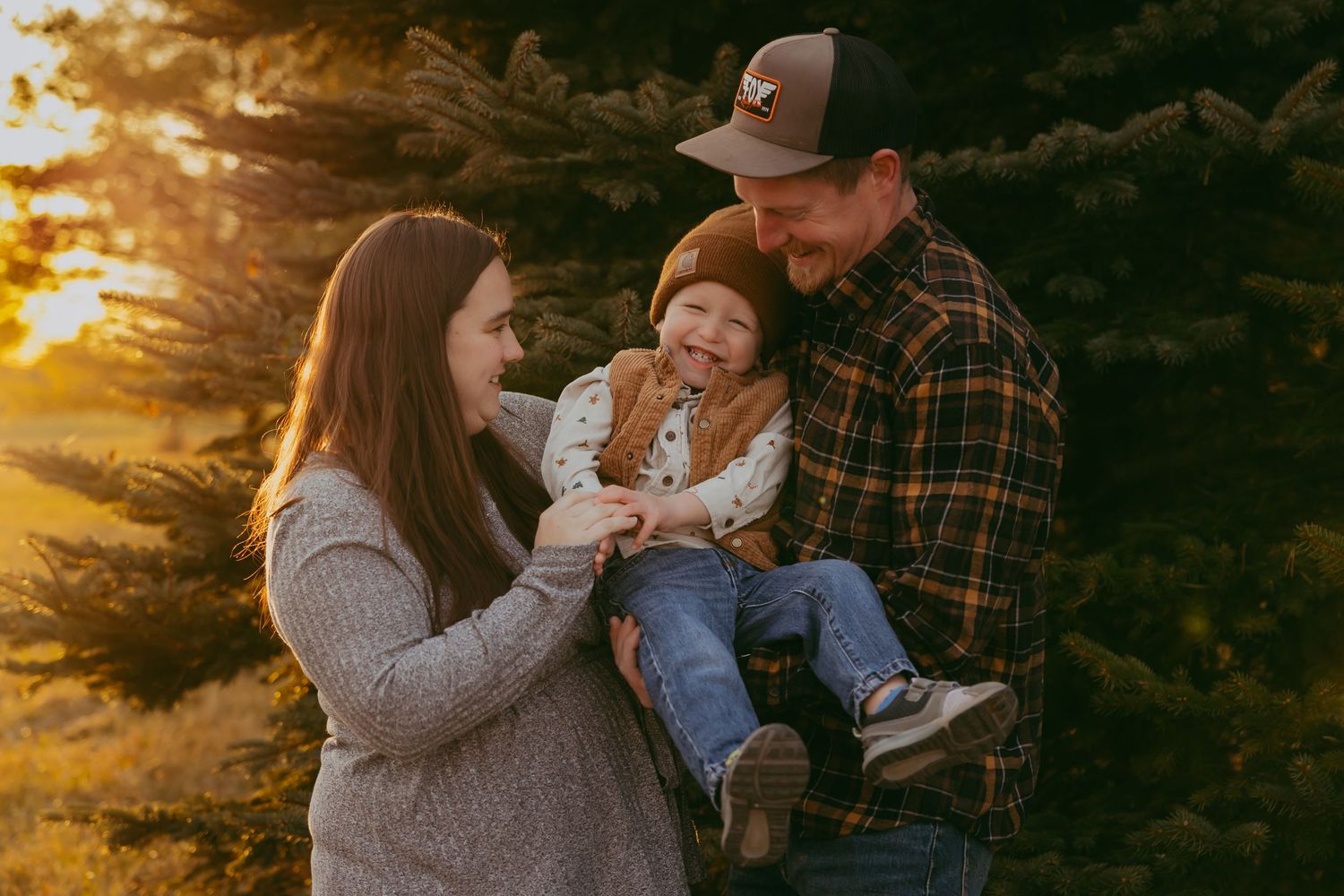 Candid family moment playing together in tall grass.