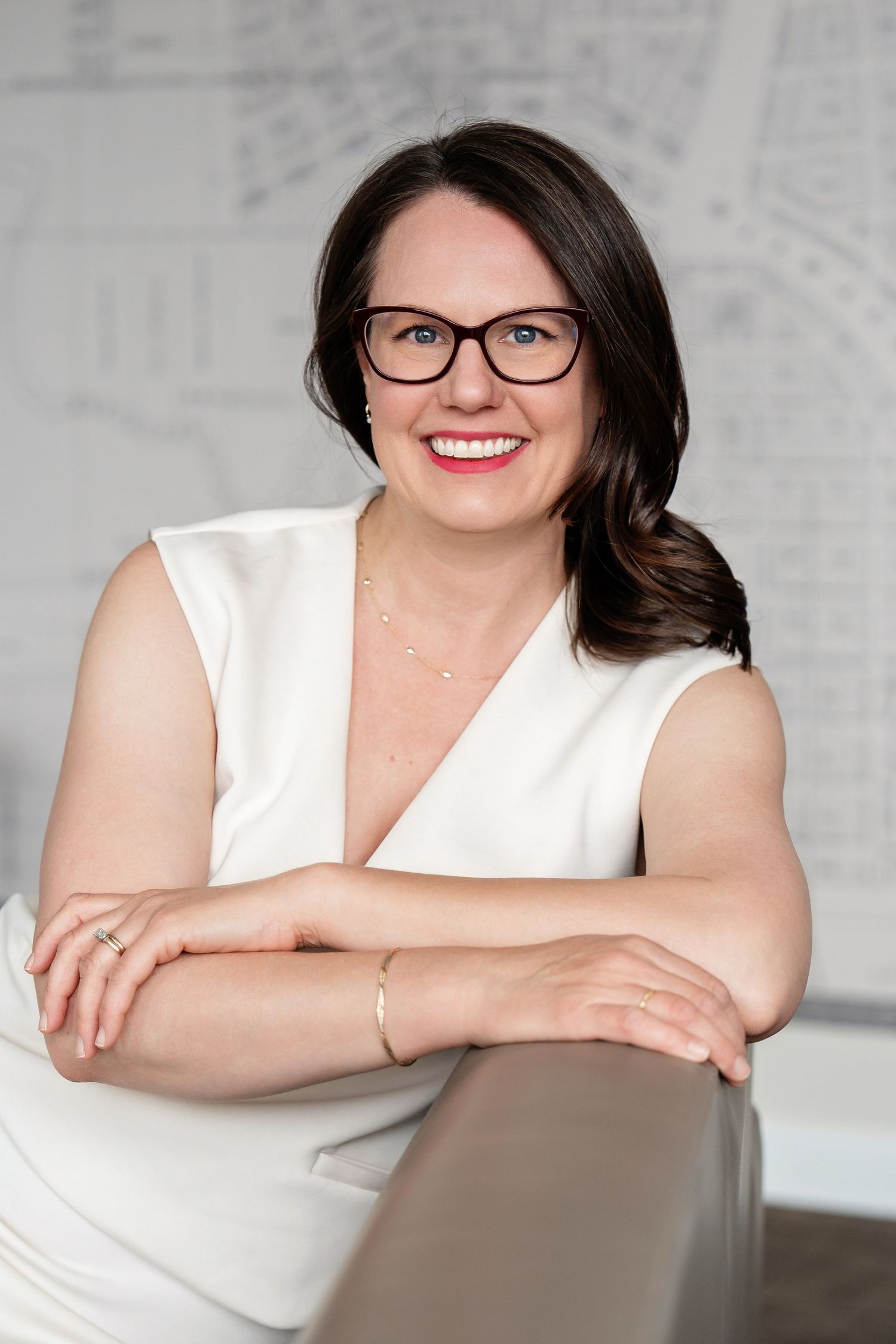 Headshot of a woman leaning on a couch with interesting wallpaper taken by Milwaukee headshot and branding photographer Rachel Dickman.