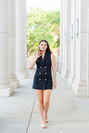 Fashion portraits in navy blazer dress along classic white columned walkway.