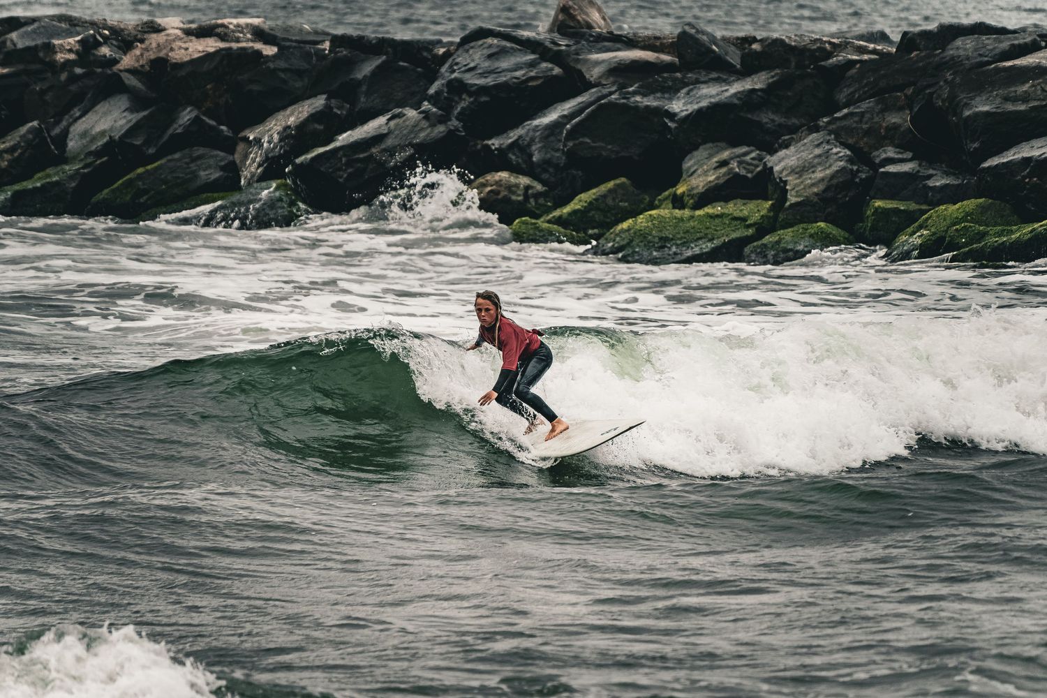 A surfer rides a wave while performing dynamic turns and maneuvers on a surfboard in the ocean.