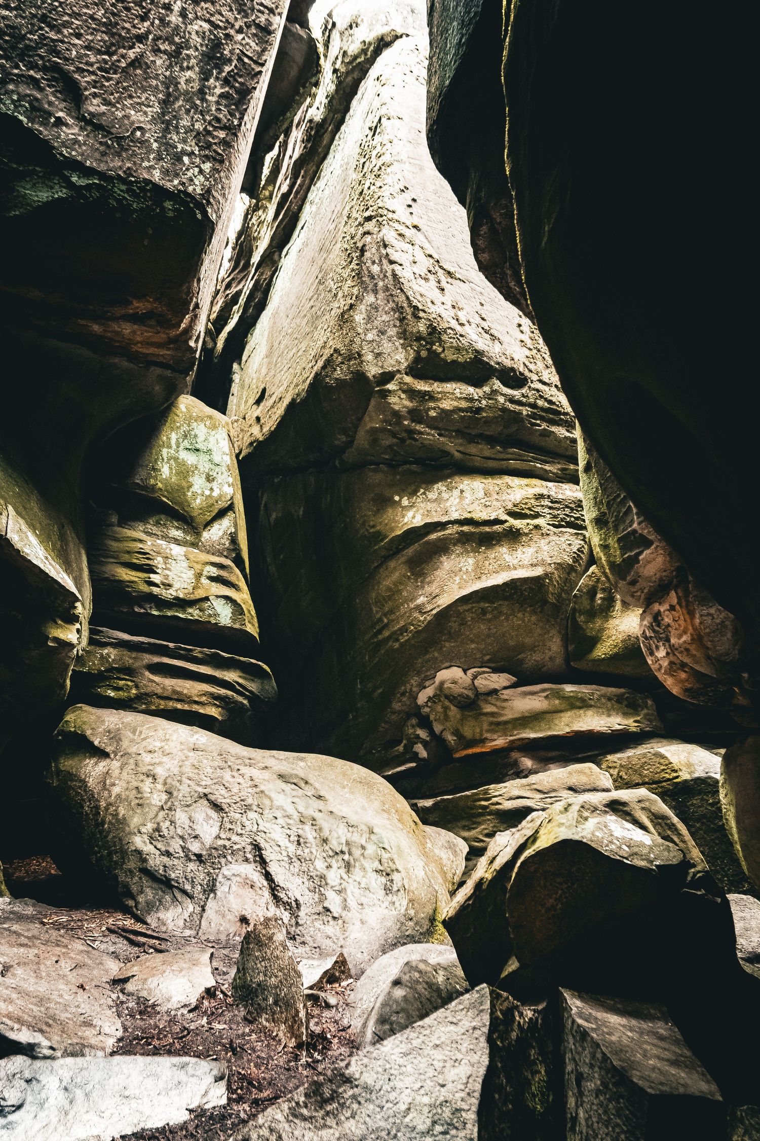 Close-up view of layered rock formations inside a dark cave showing natural erosion patterns and textures.