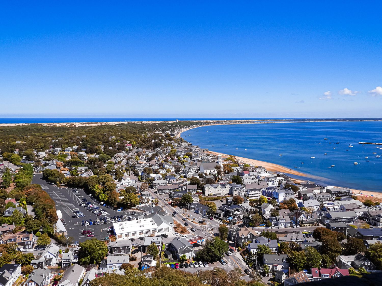 Aerial panoramic view of Provincetown Massachusetts showing dense coastal buildings and beaches along Cape Cod Bay.