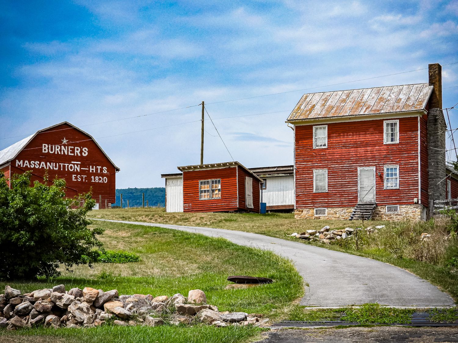 Historic red buildings along a winding country road with rustic charm.