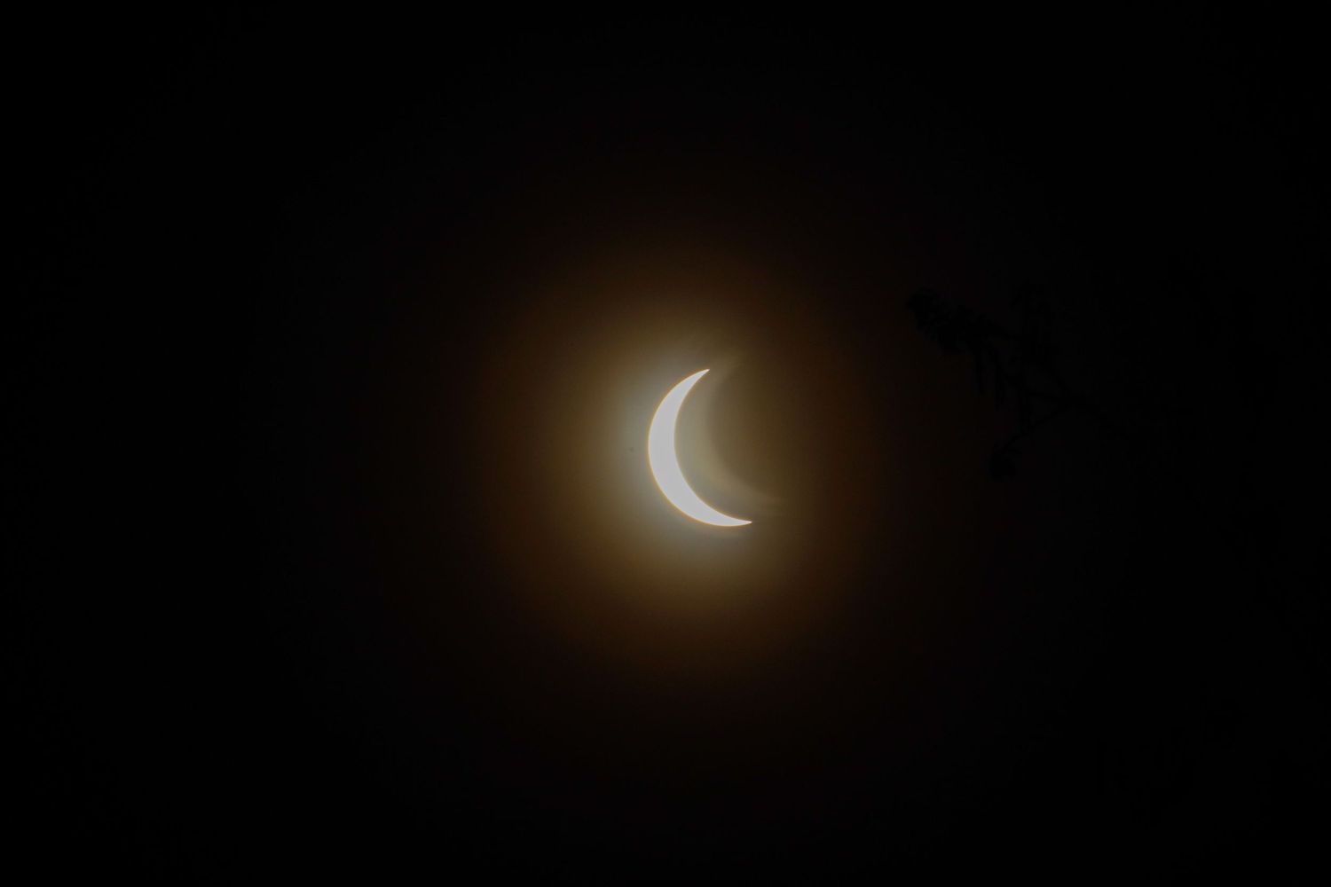 Crescent moon glowing in dark night sky with a warm halo effect.