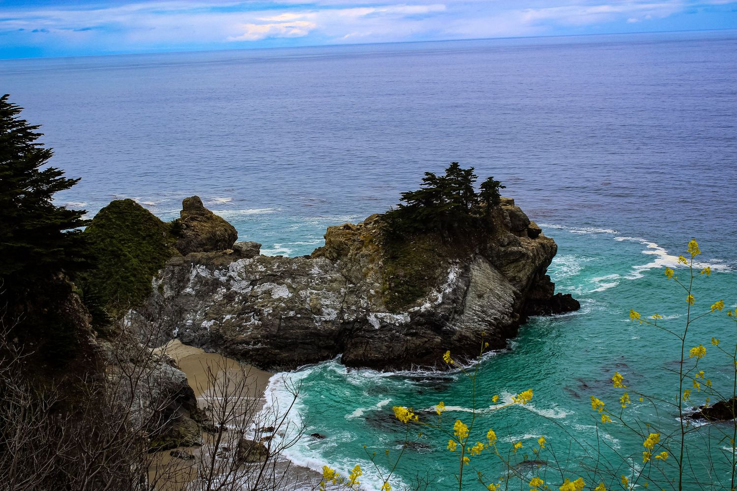 Turquoise waters meet rocky cliffs at McWay Falls cove in Big Sur, California.