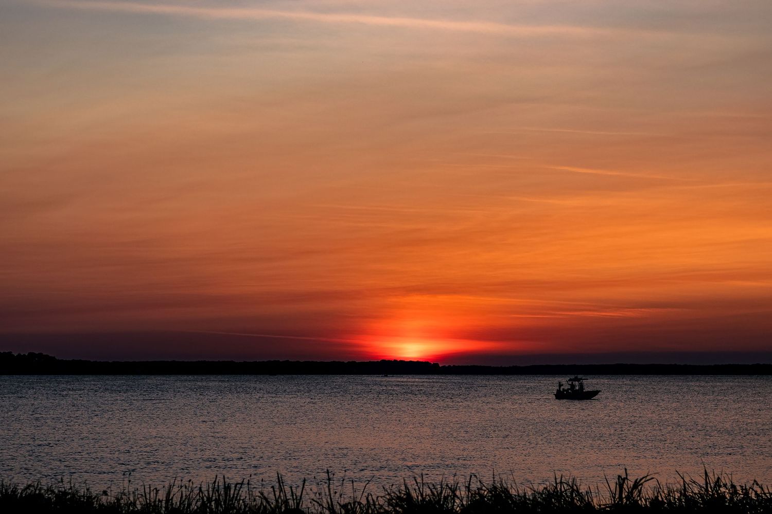 A series of sunset photos over water showing the progression from golden hour to dusk with a silhouetted boat.