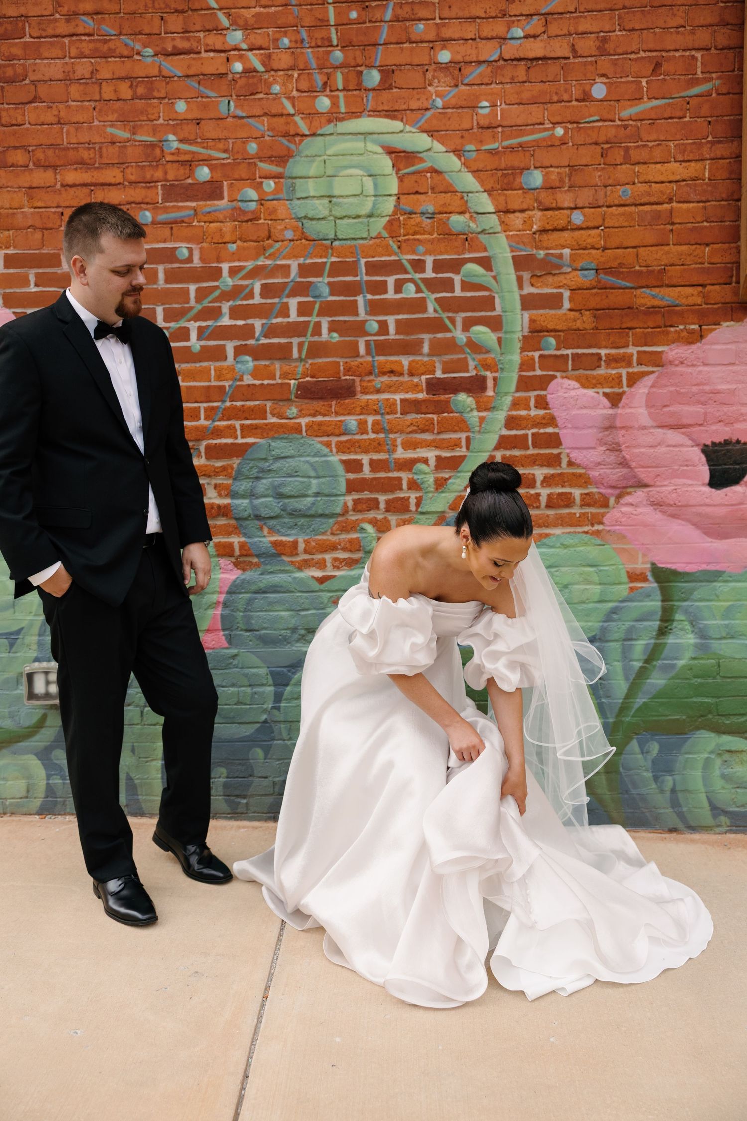 A series of four wedding photos showing a couple sitting against a brick wall with painted floral murals.
