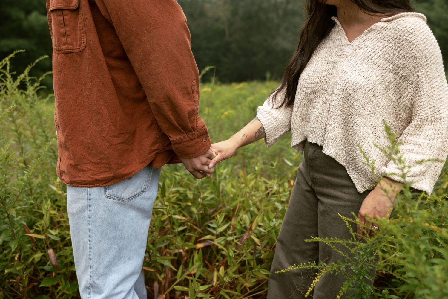 People walking through a rustic garden path surrounded by autumn foliage and natural landscaping.