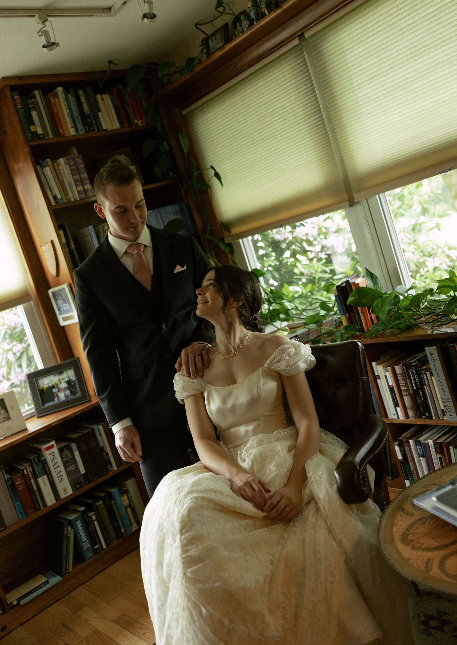 Indoor wedding portraits in a cozy library setting with natural window light.