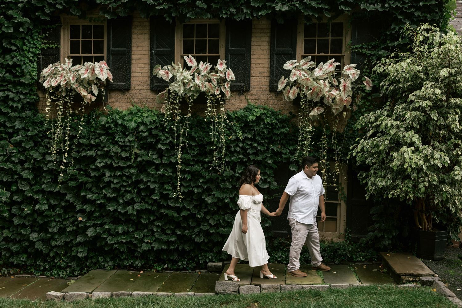 A garden path surrounded by lush green foliage and ivy-covered walls creates a romantic outdoor setting.