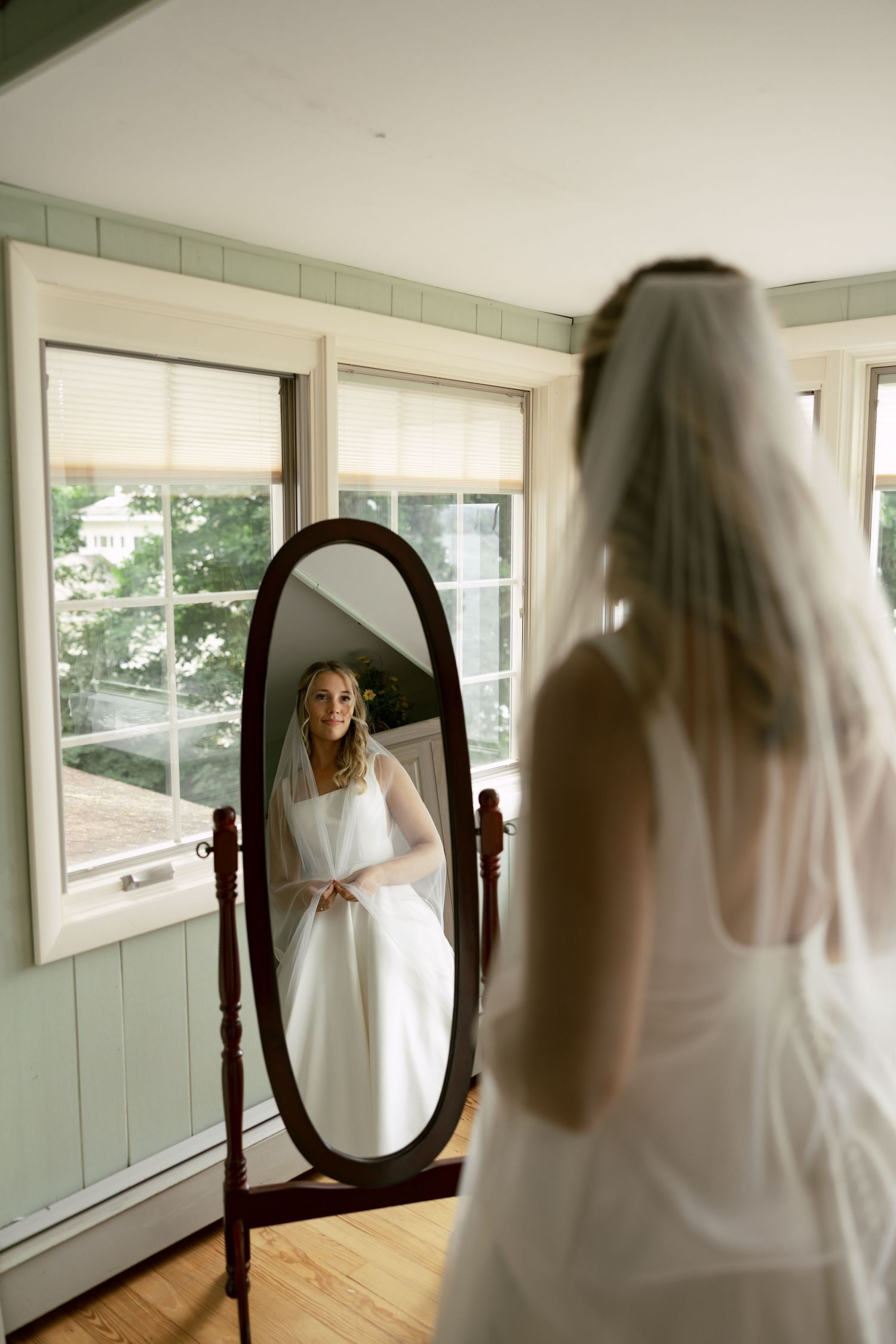 A series of mirror reflections showing a wedding dress in a bright room.