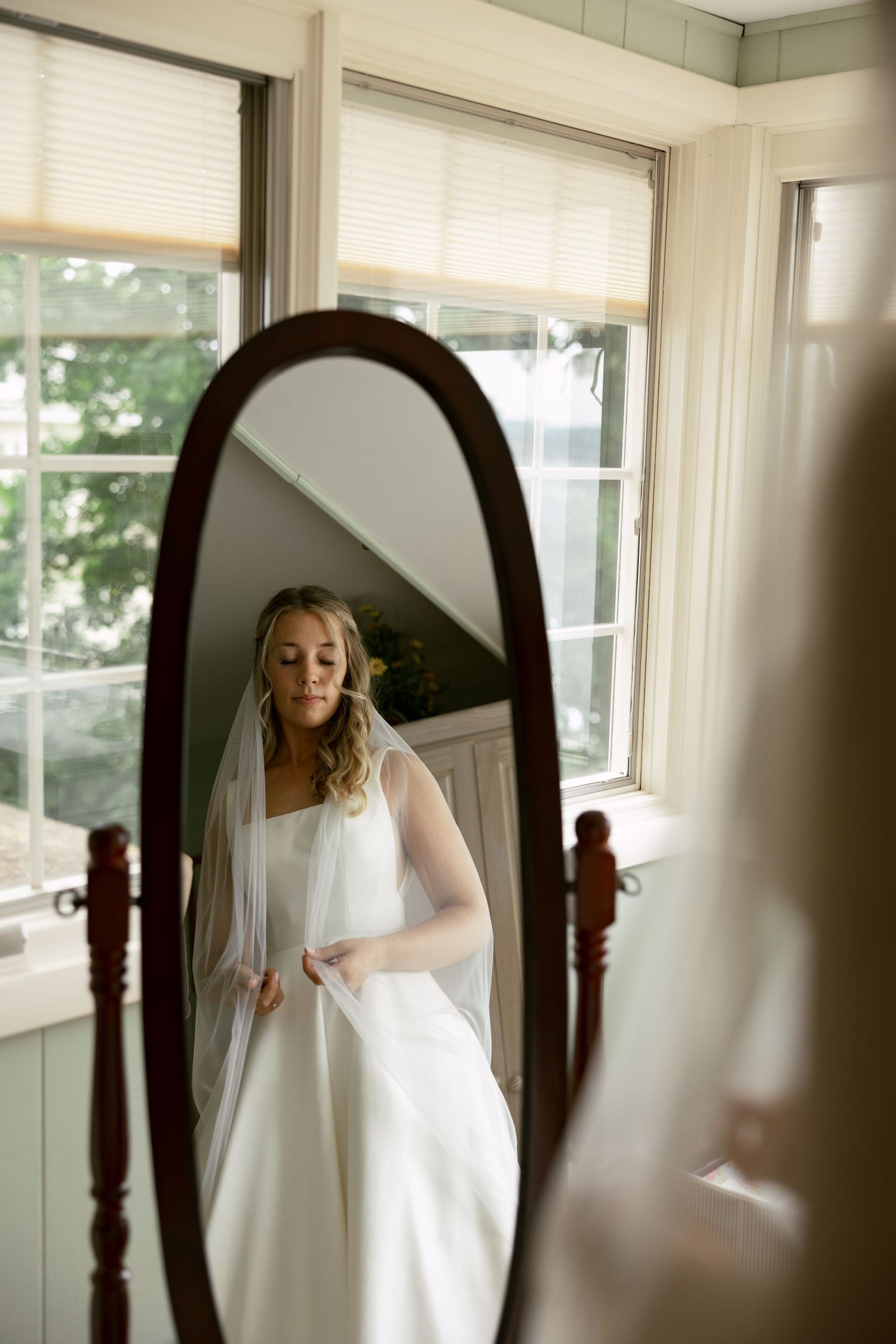 Multiple reflections of a wedding dress captured in an elegant room with natural light.