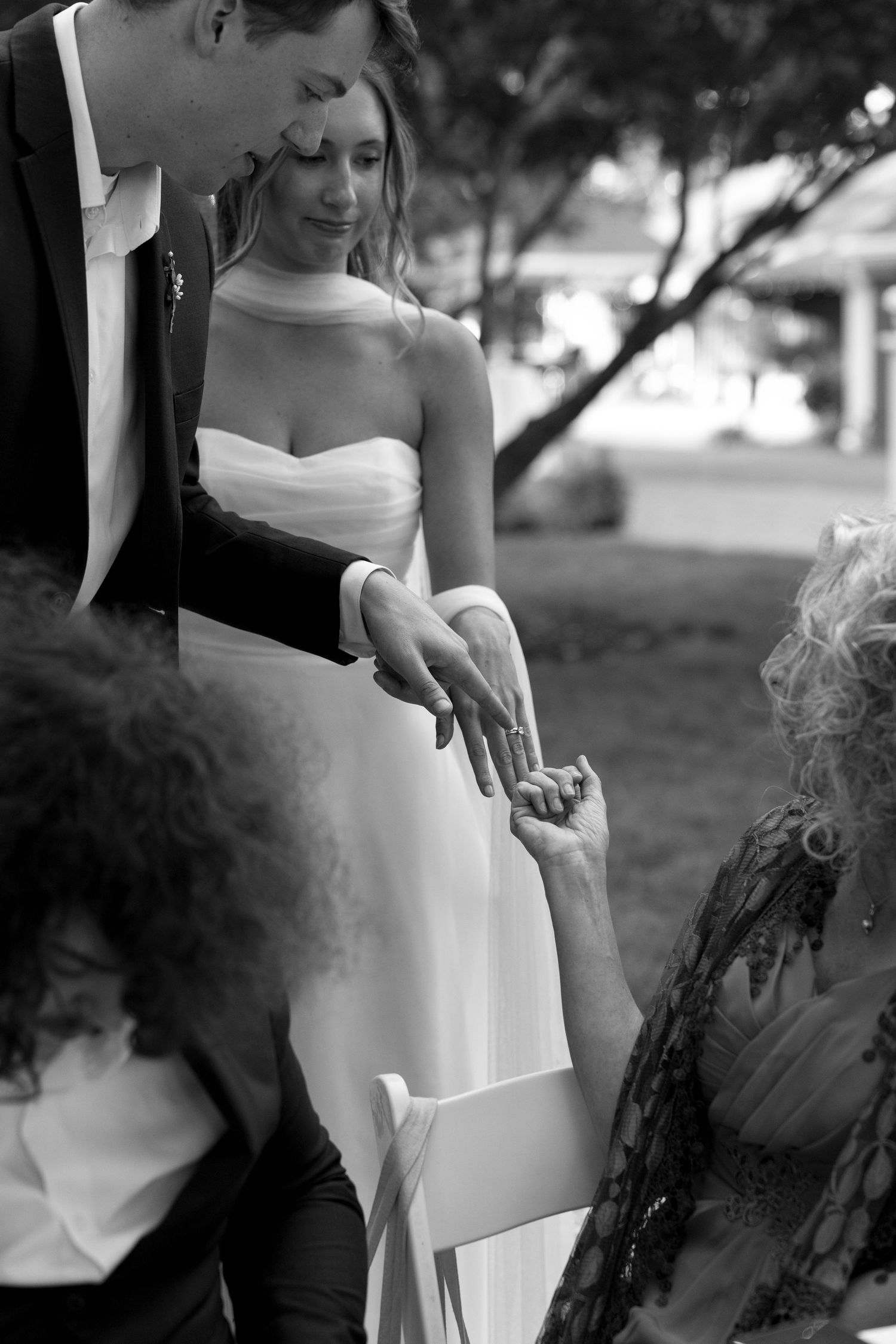 An intimate black and white moment captured during wedding preparations with elegant formal attire.
