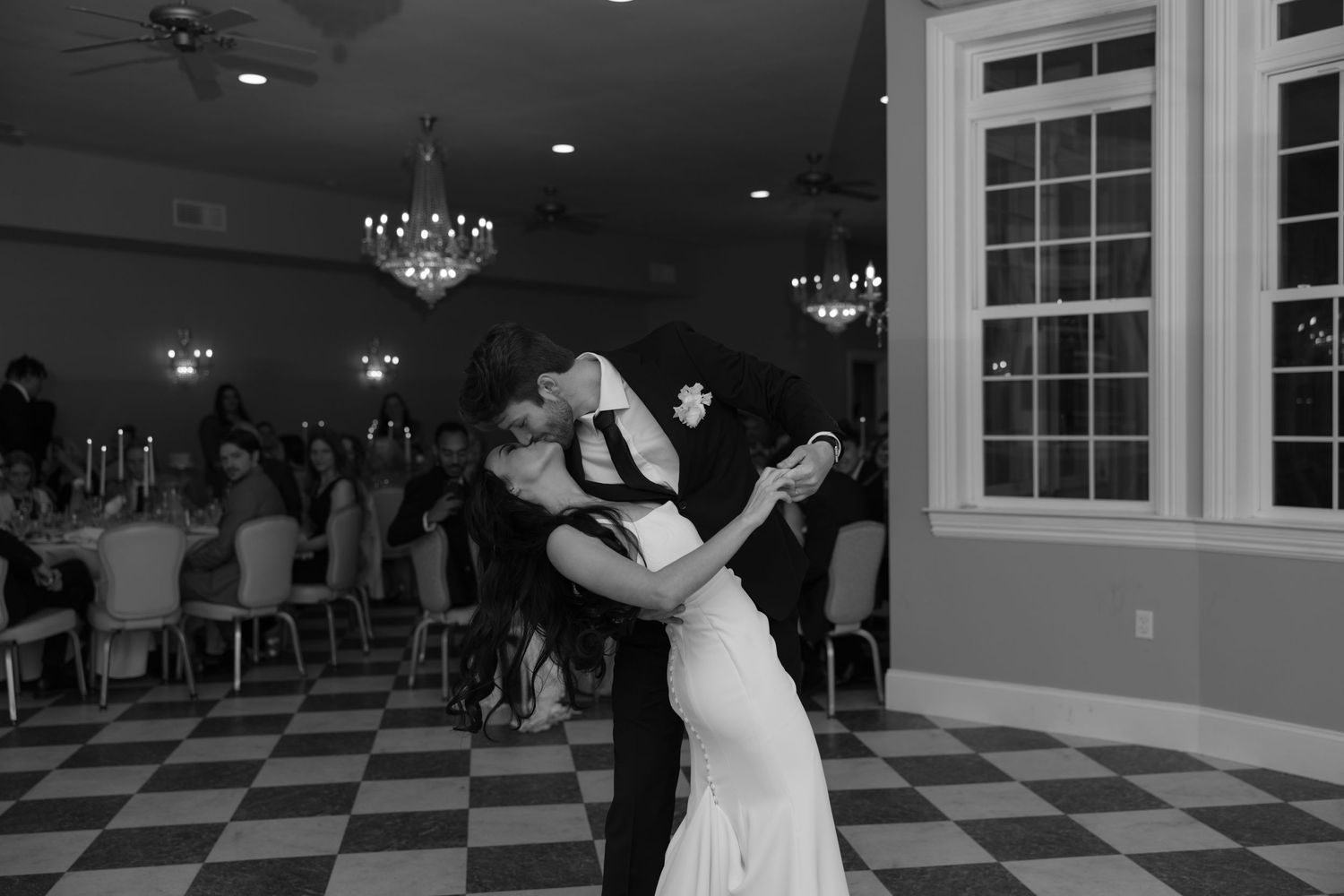 Wedding reception dance floor with guests celebrating under dim lighting.