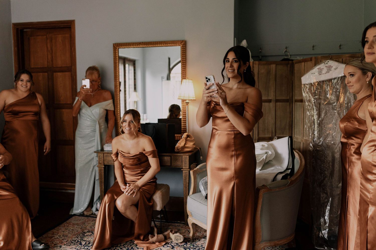 Wedding party in earth-toned dresses preparing in an elegant room.