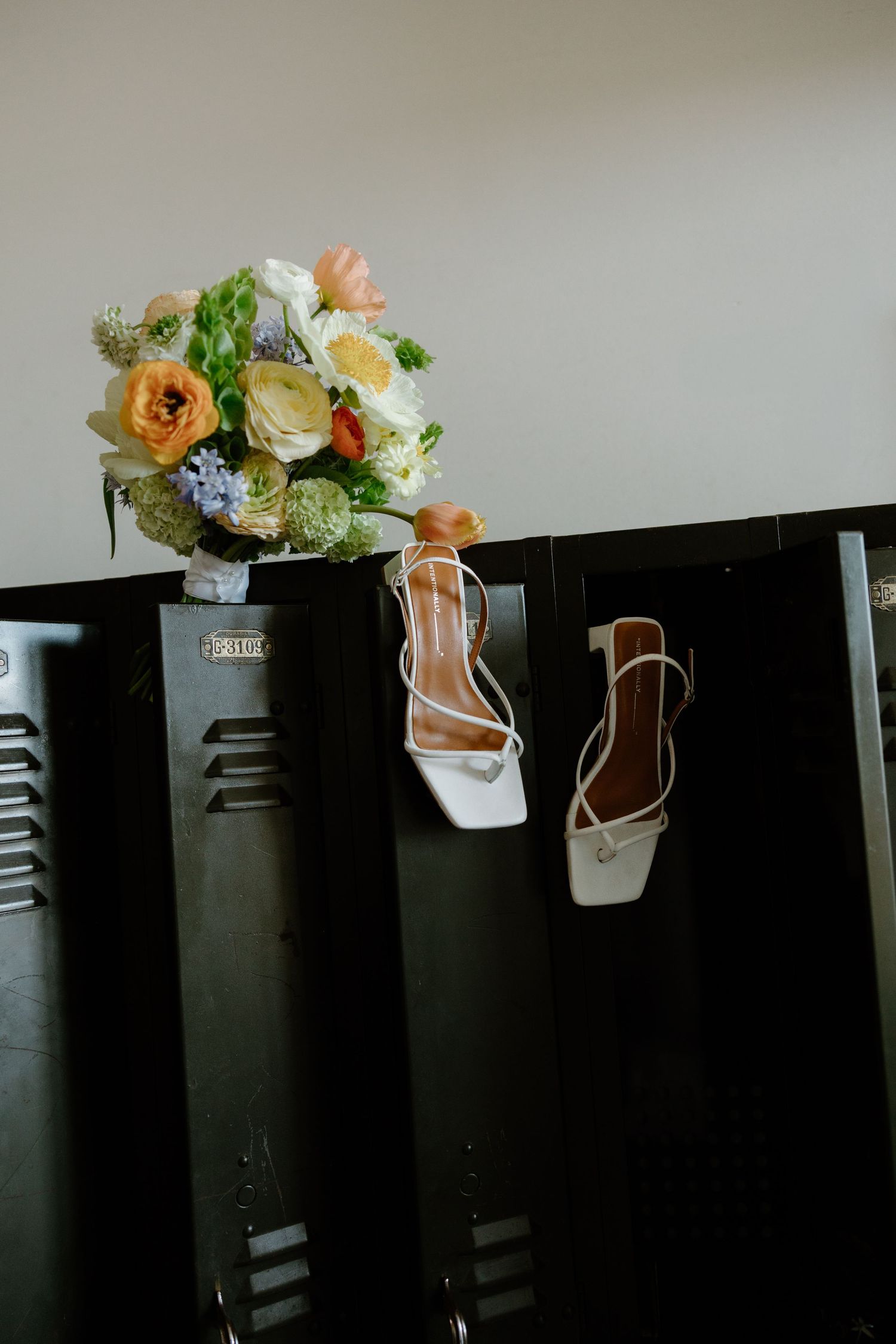 Peach and cream floral arrangements displayed on dark lockers.
