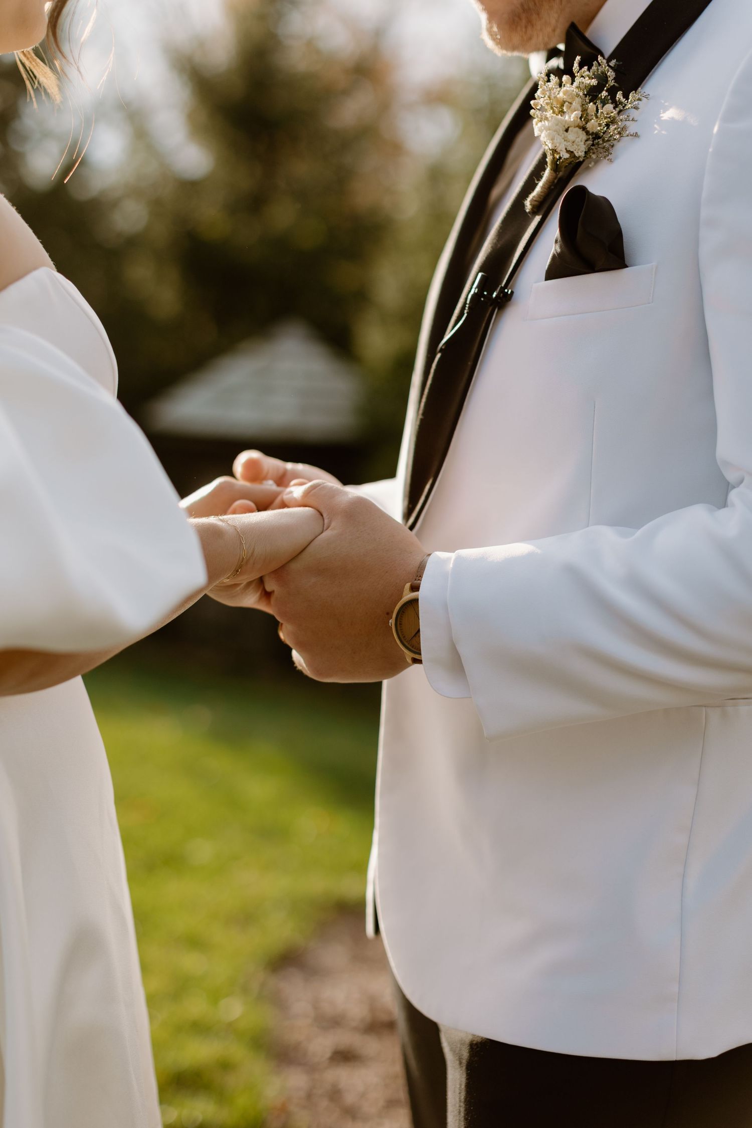 Close-up shots of hands exchanging wedding rings during an outdoor ceremony.