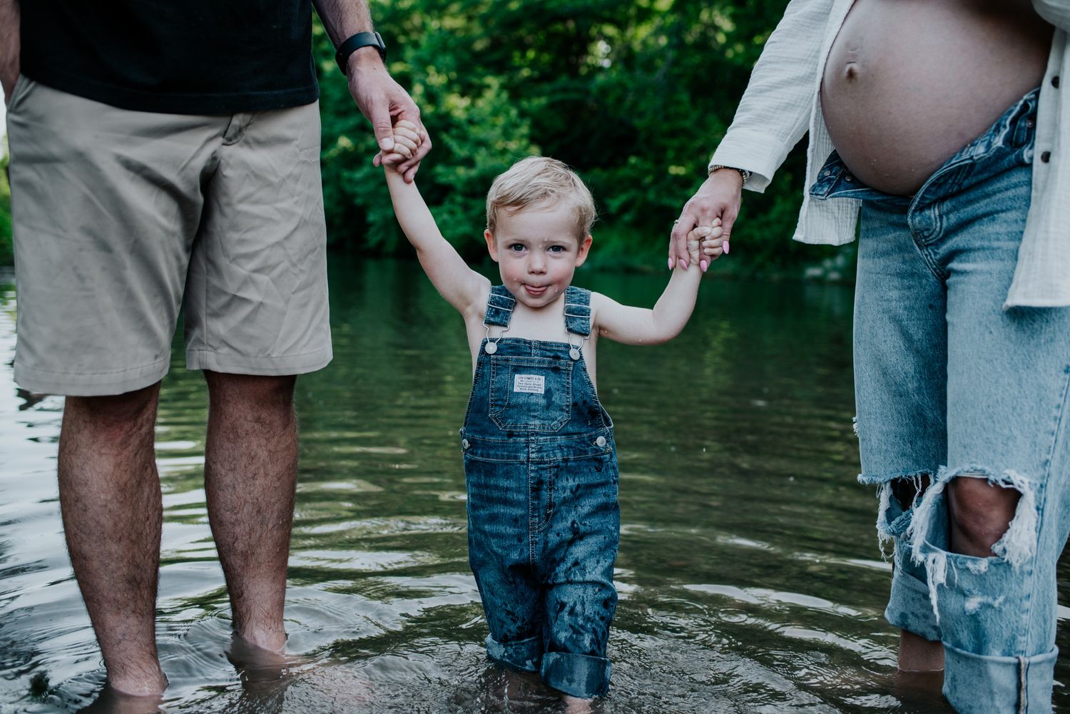 A family enjoys a warm summer day playing in shallow water together.
