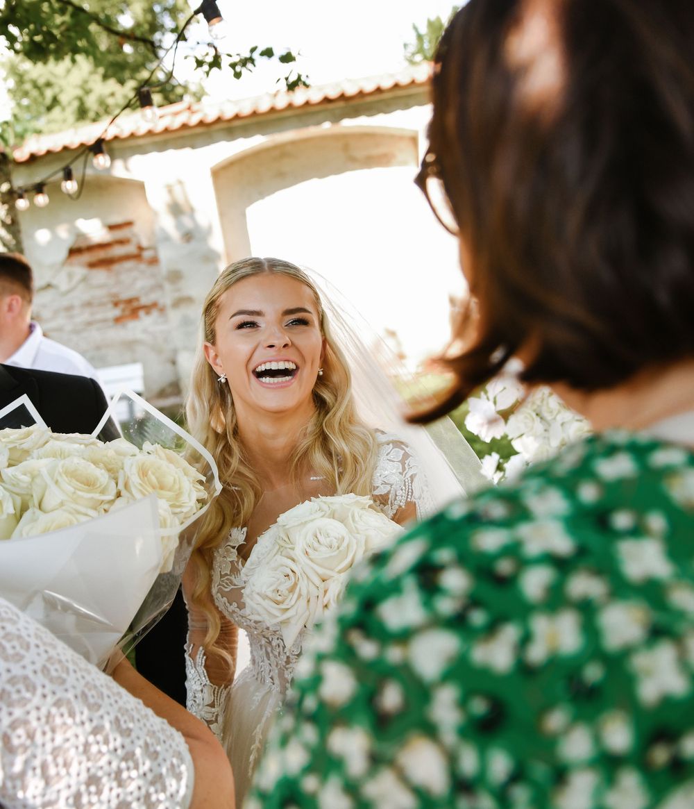 Wedding celebration scene with white roses and floral decor in a sunny outdoor setting.