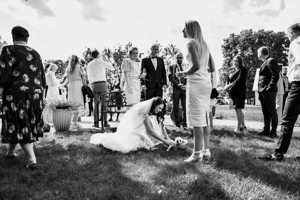 Black and white photo of wedding guests gathered on lawn during outdoor celebration.