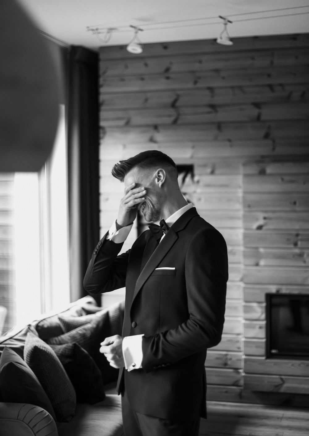 A black and white photo series shows a person in a suit making various emotional gestures in a wood-paneled room.