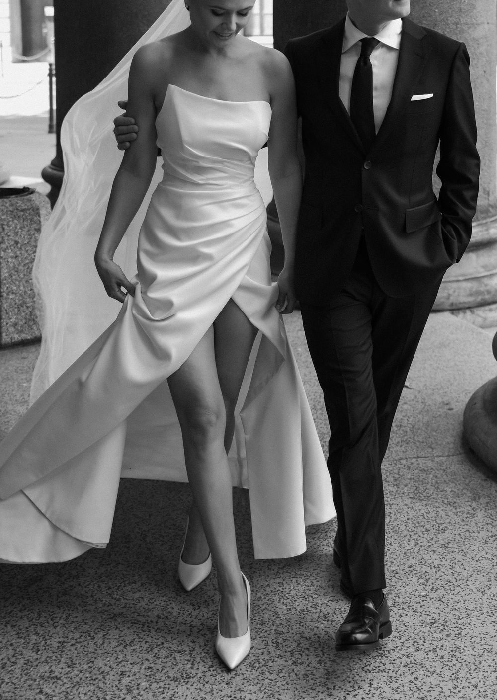 Modern bridal fashion with sleek white dress and classic black tuxedo.