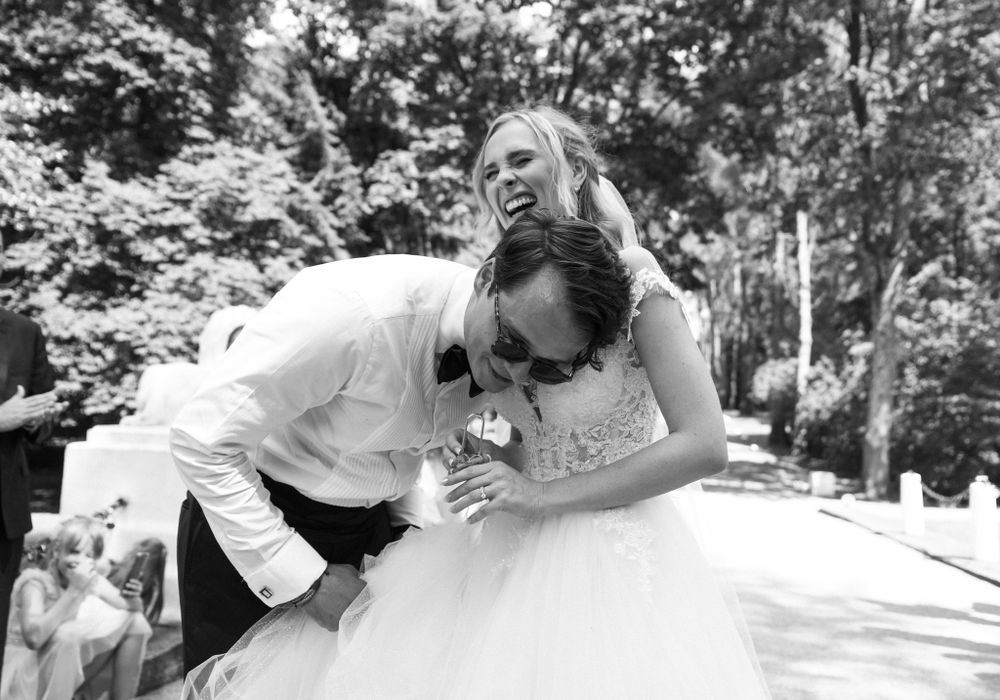 A wedding moment captures pure joy and laughter between a couple in formal attire.