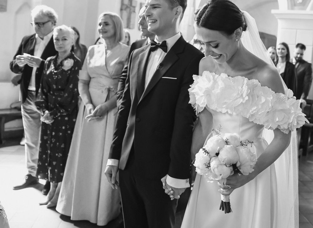 Black and white photo of a wedding ceremony with guests observing the couple.