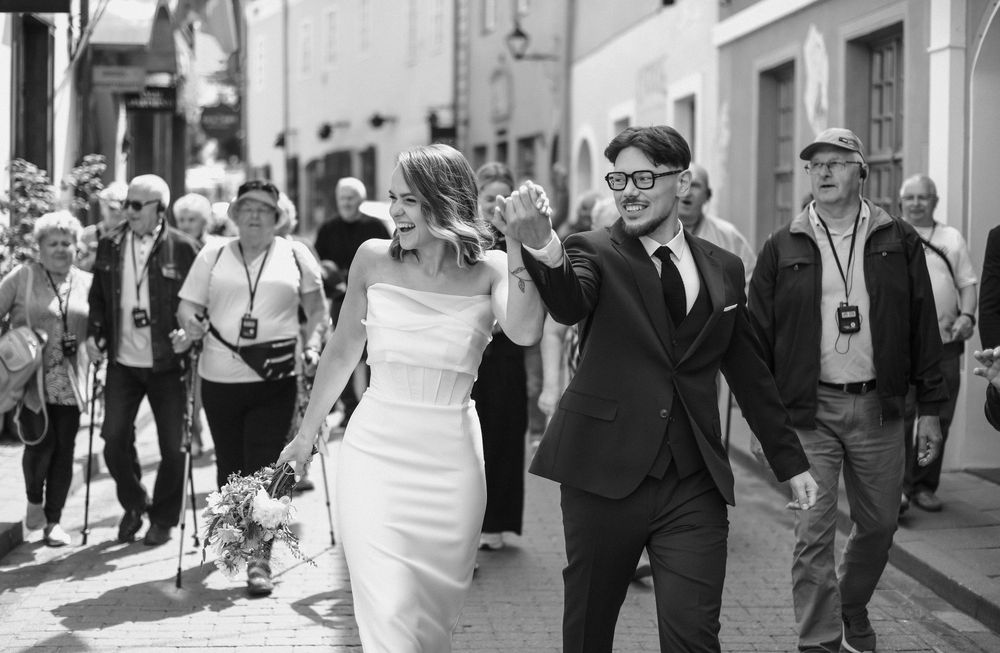 A black and white collage of wedding moments showing couples and guests walking and celebrating at various locations.
