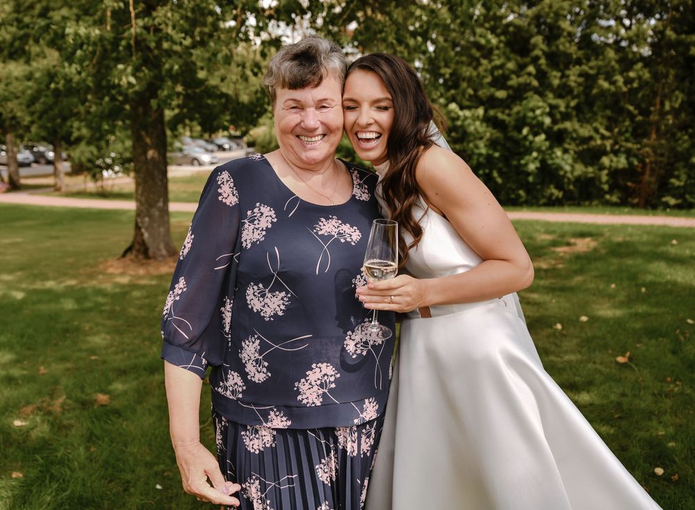 A couple shares a joyful moment together outdoors in a lush green garden setting.