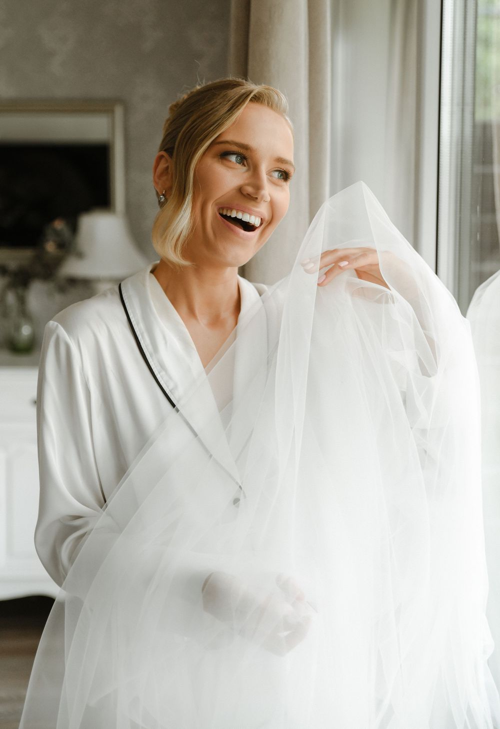 A series of getting ready moments showing someone in a white robe by a bright window.