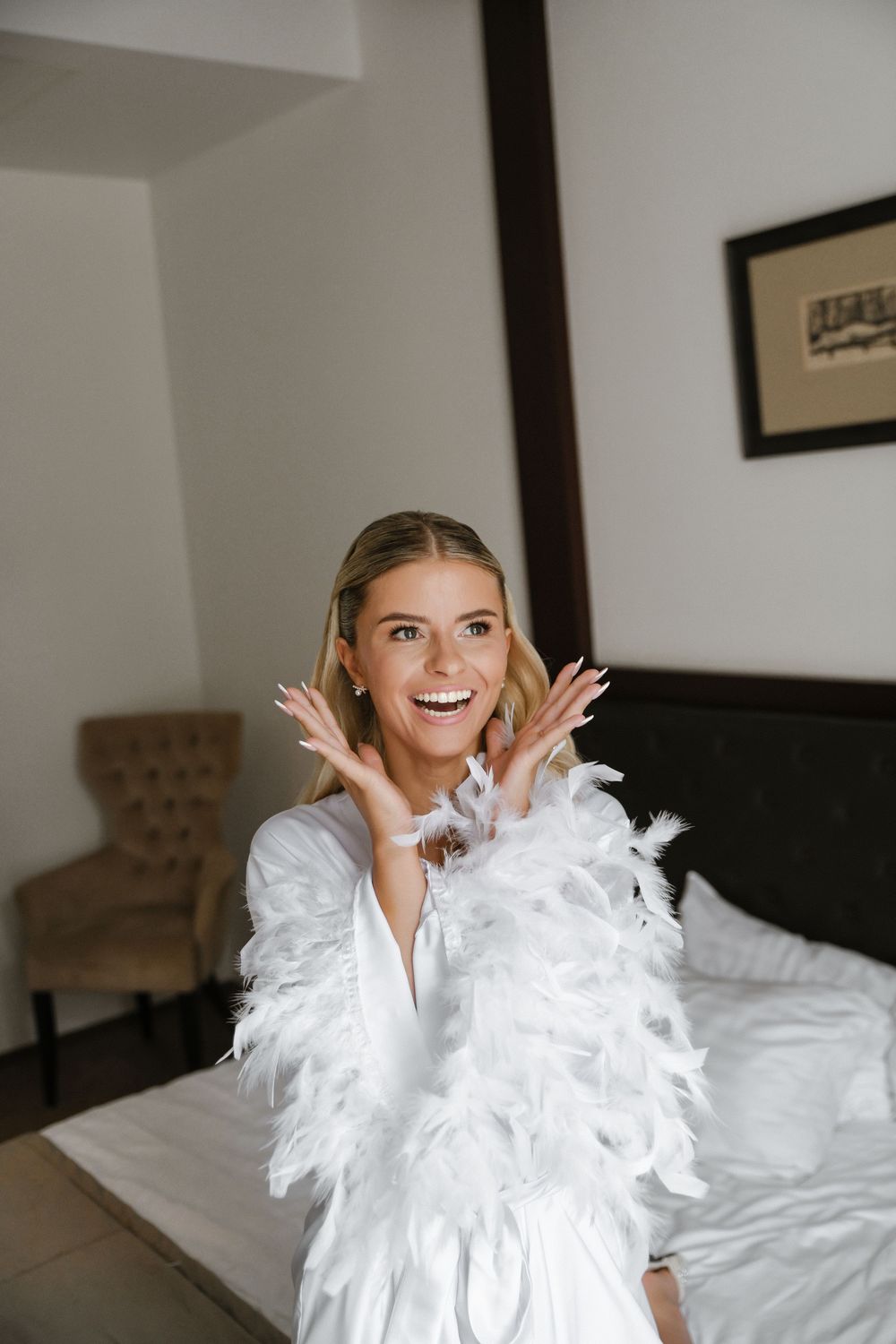 A series of photos showing someone wearing a white feathered outfit while posing playfully on a bed.