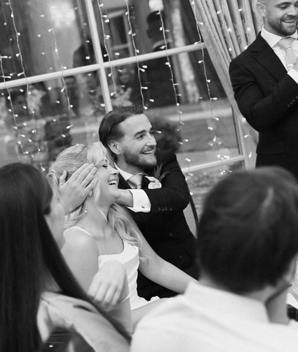 Happy newlyweds smile and celebrate with guests as confetti falls during their wedding reception.