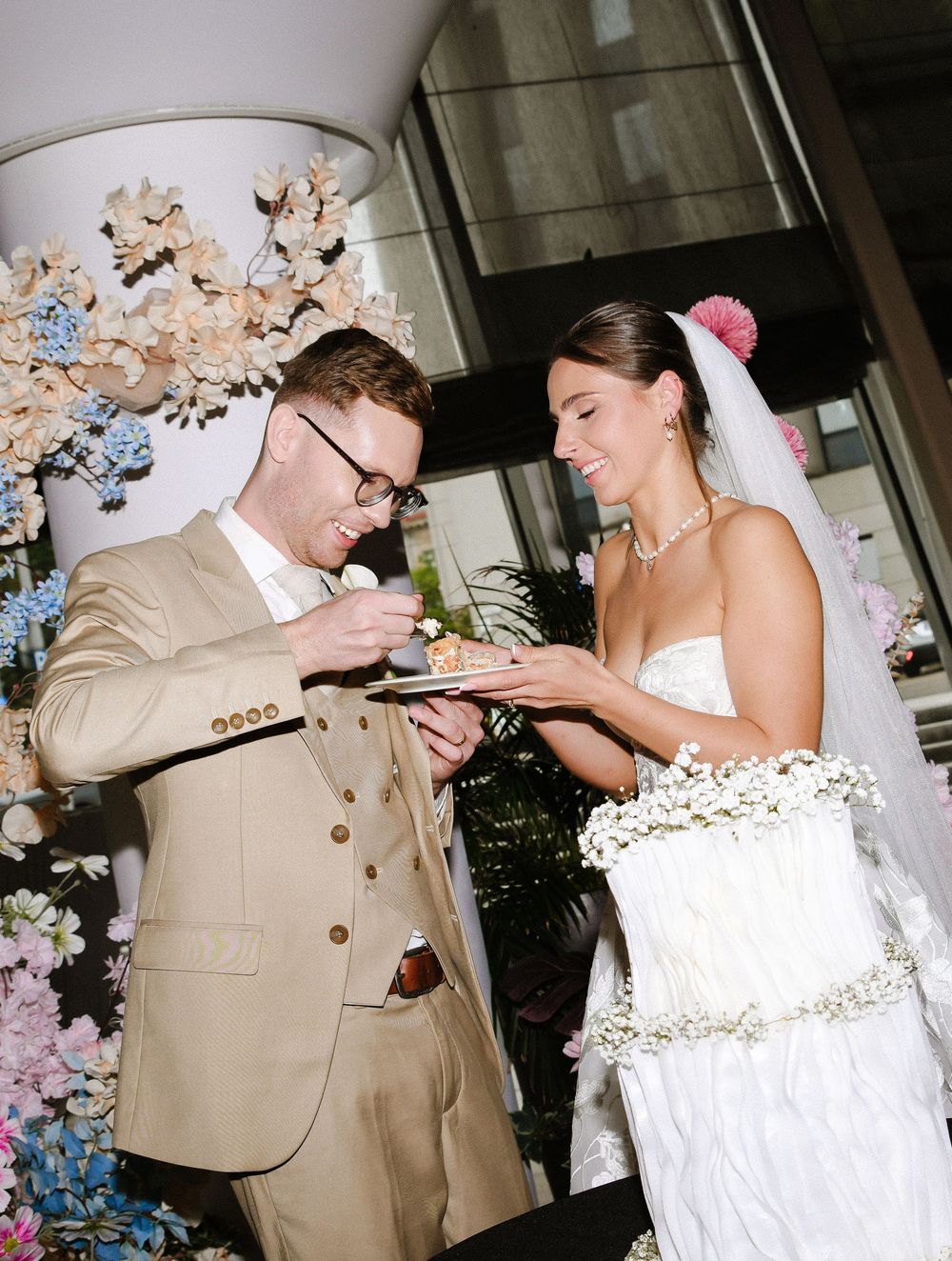 A couple playfully sharing their wedding cake during the traditional cake cutting ceremony at their reception.
