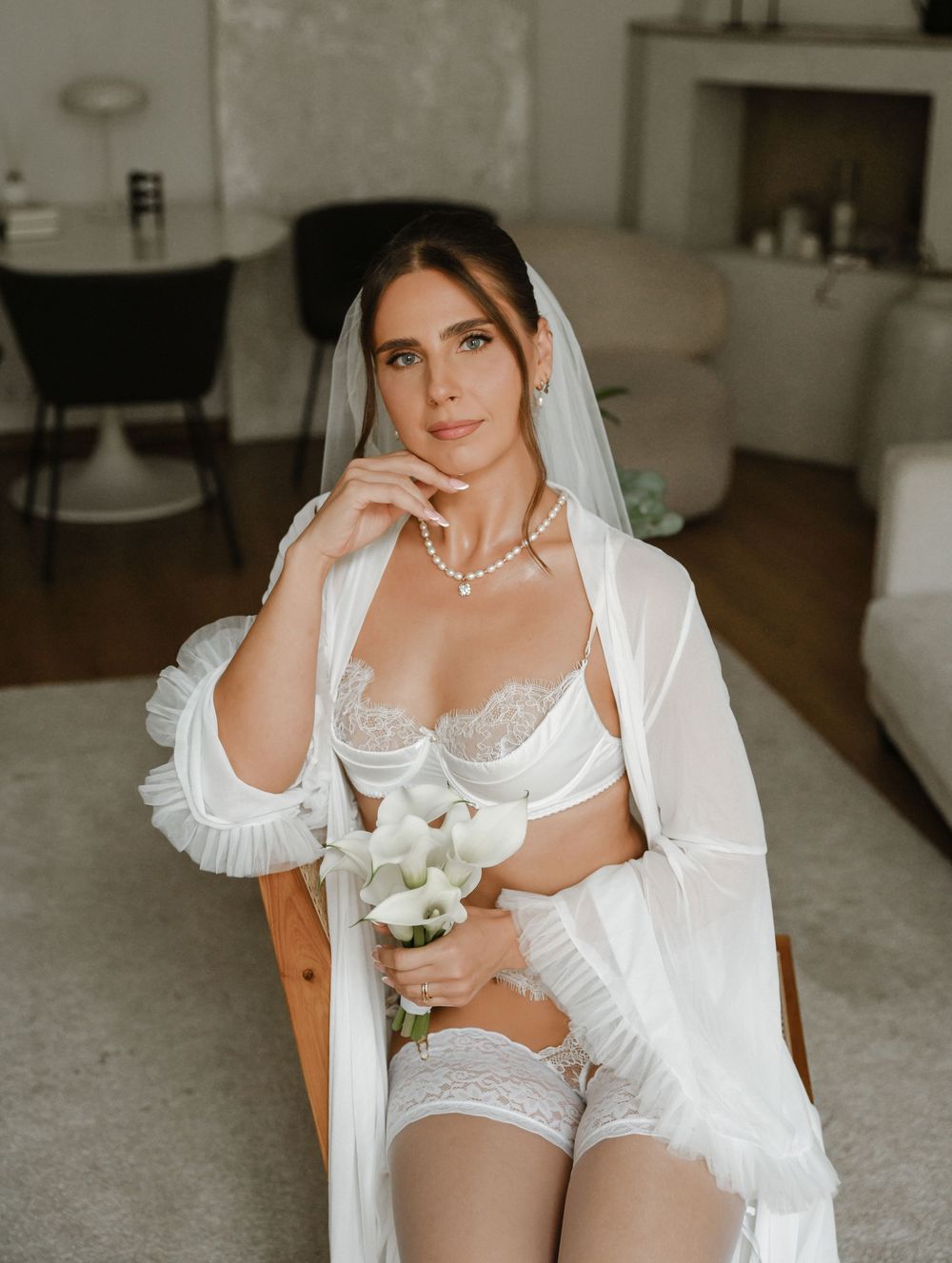 Four boudoir photos showing a figure in white lingerie and veil posing elegantly on light furniture.