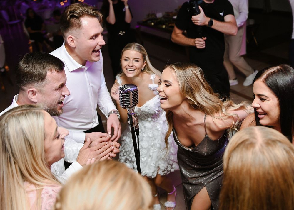 Wedding guests dance and celebrate on a crowded dance floor during an energetic reception party.